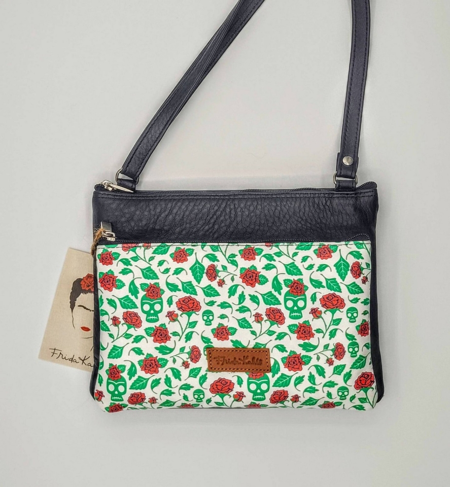 Bossa mini bandolera confeccionat en pell amb estampat de calaveres i flors inspiració Frida Kahlo. Disponible en negre, blau, lila, vermell, verd.